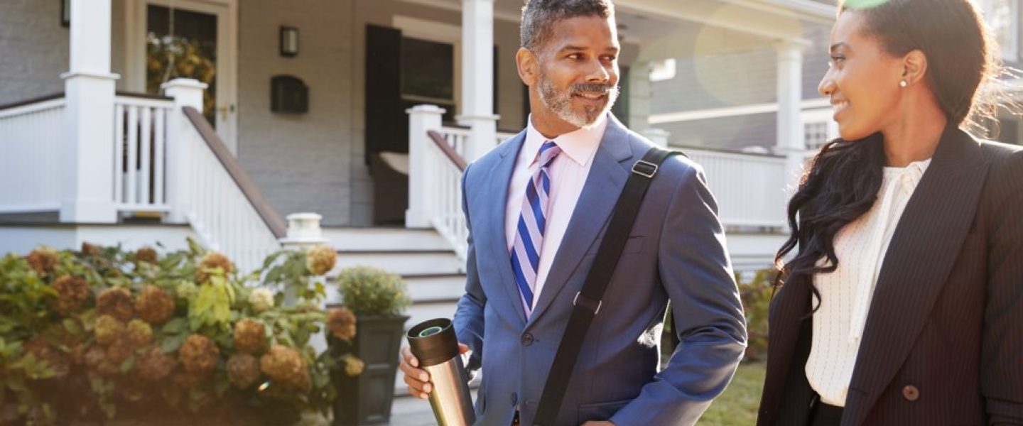 Business Couple Leaving Suburban House For Commute To Work