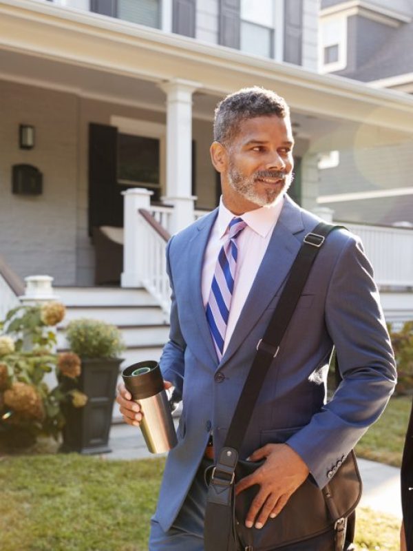 Business Couple Leaving Suburban House For Commute To Work